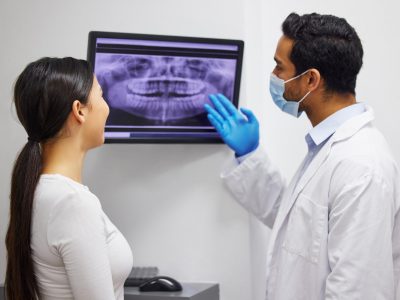 a dentist discussing the results of a patients teeth x ray.